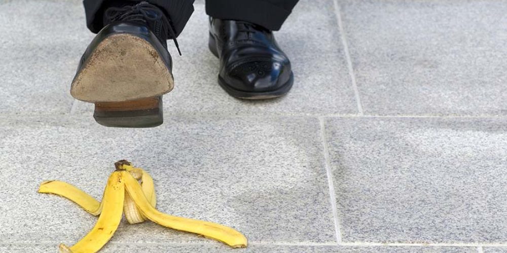 Businessman stepping on banana skin, copy space